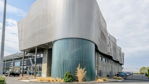 A modern building with a curved facade and a large cylindrical section.