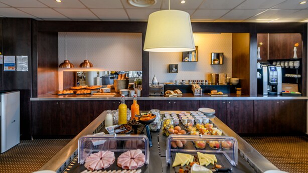 A buffet area with various food items and a coffee station.