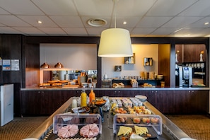 A buffet area with various food items and a coffee station.