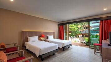 Habitación de hotel con dos camas, un escritorio, una silla y vistas a un jardín y una piscina.