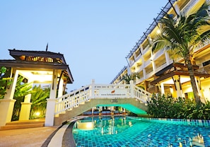 A hotel with a swimming pool, a bridge, and a website address.