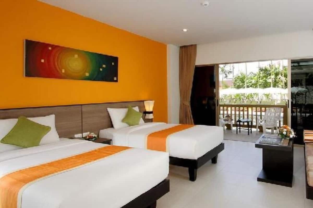 Een hotelkamer met twee bedden, een schilderij aan de muur en een balkon met tuinmeubilair.