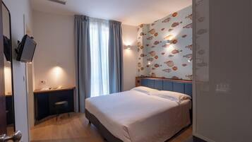 Een hotelkamer met een bed, een bureau en een stoel.