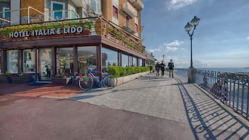 Un hotel con balcón, mobiliario exterior y vista al mar.