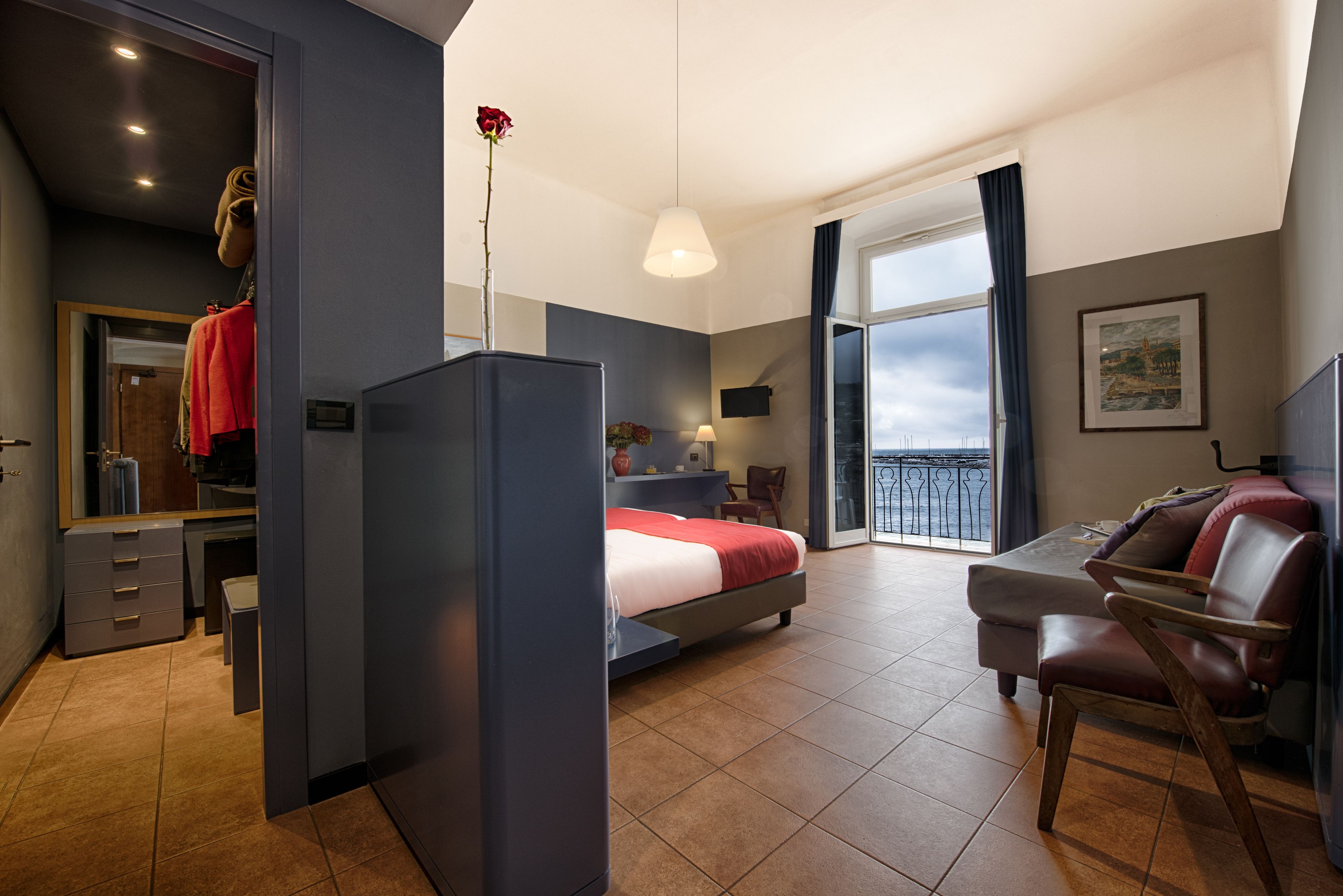 Une chambre moderne avec un lit, un bureau, une chaise et un balcon offrant une vue agréable.