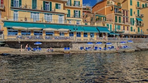Un hotel frente al agua con terraza y vista al mar.