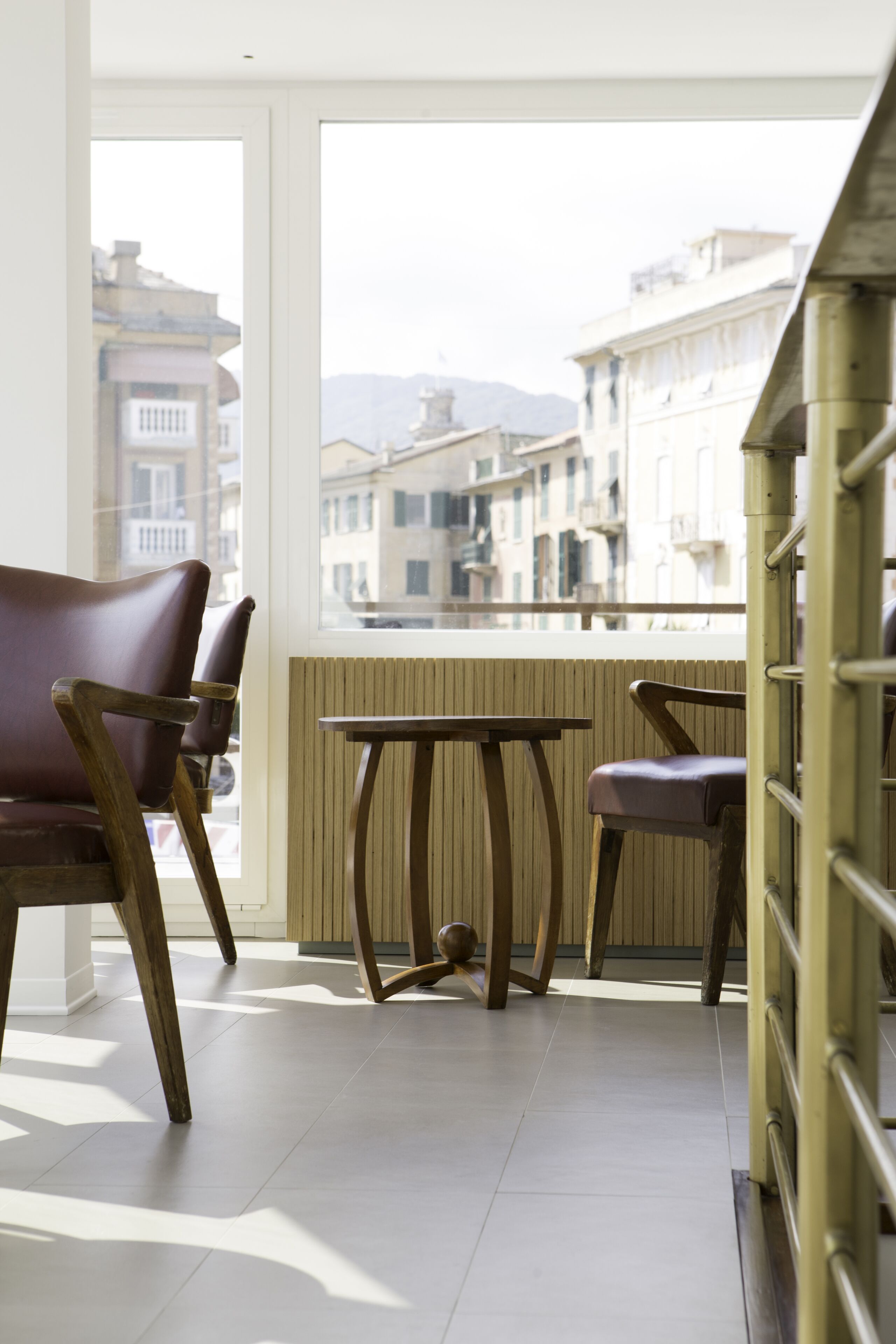 Ein Balkon mit Blick auf Gebäude, einem Holztisch und zwei Stühlen.