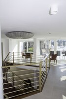 Un balcón amplio con comedor, una escalera y vistas a la ciudad.