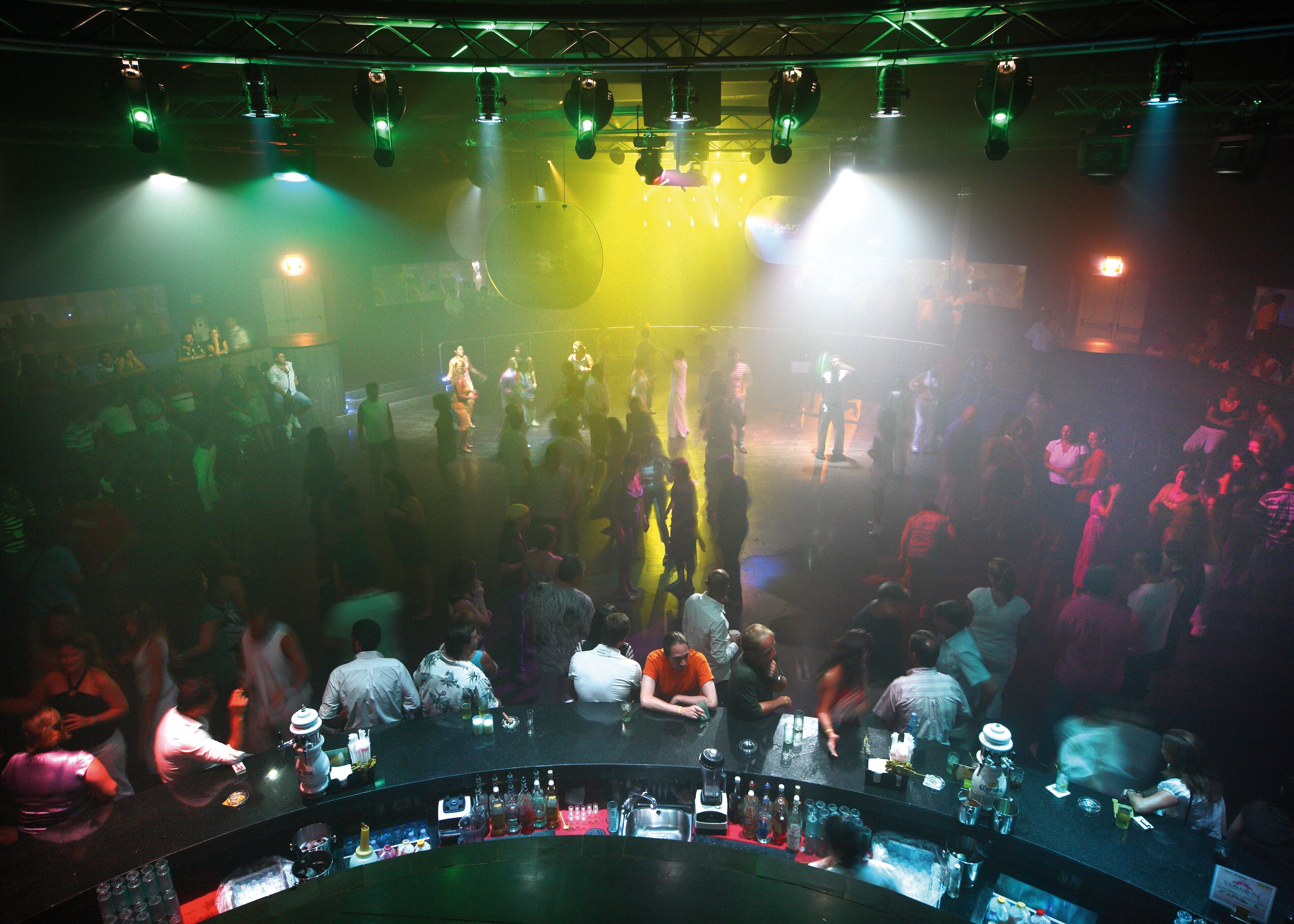 Un bar concurrido con un escenario y público.