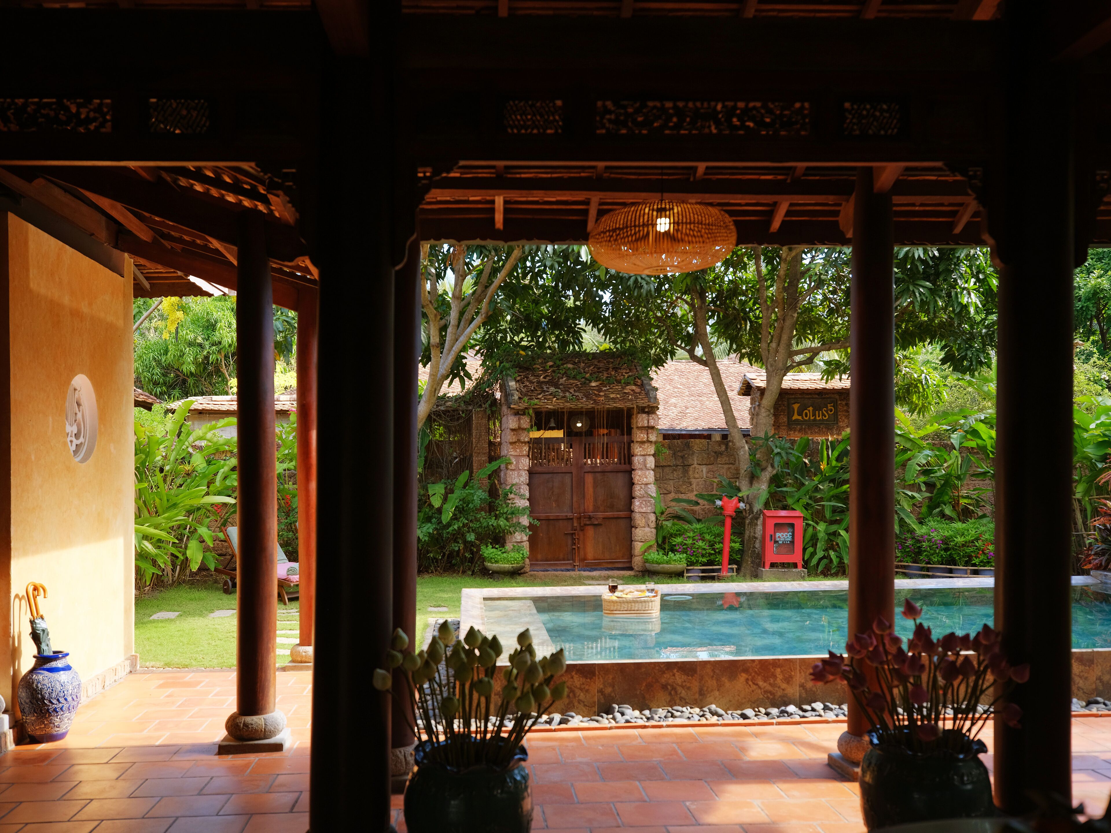 A pool area with a stone wall, a wooden door, and a sign that reads "Lulu5".