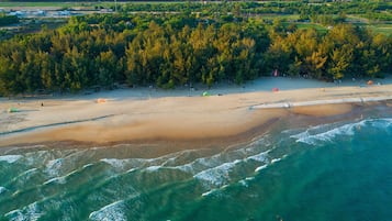 Pantai di sekitar, kursi berjemur, payung pantai, dan handuk pantai