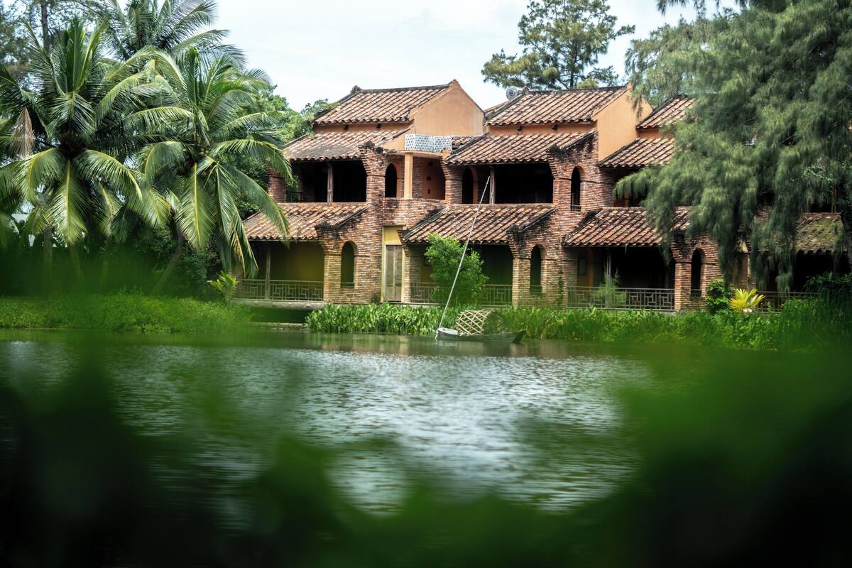 Ein traditionelles Gebäude mit mehreren Balkonen und einem Wasserbecken davor.