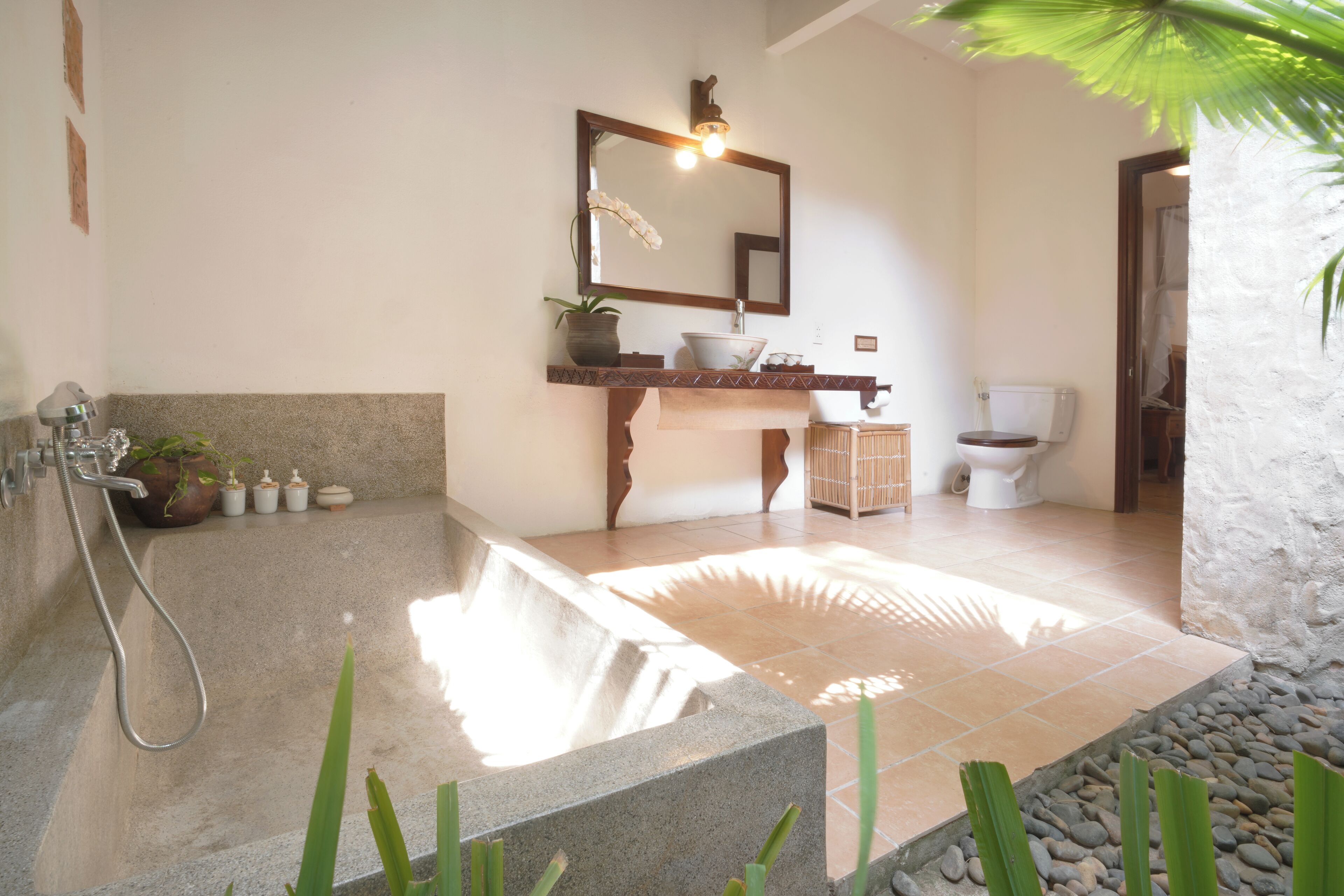 A bathroom with a freestanding bathtub, a sink with a mirror, and a toilet.