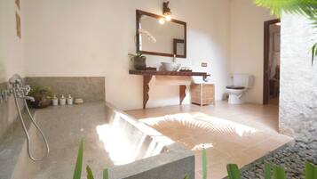 A bathroom with a freestanding bathtub, a sink with a mirror, and a toilet.