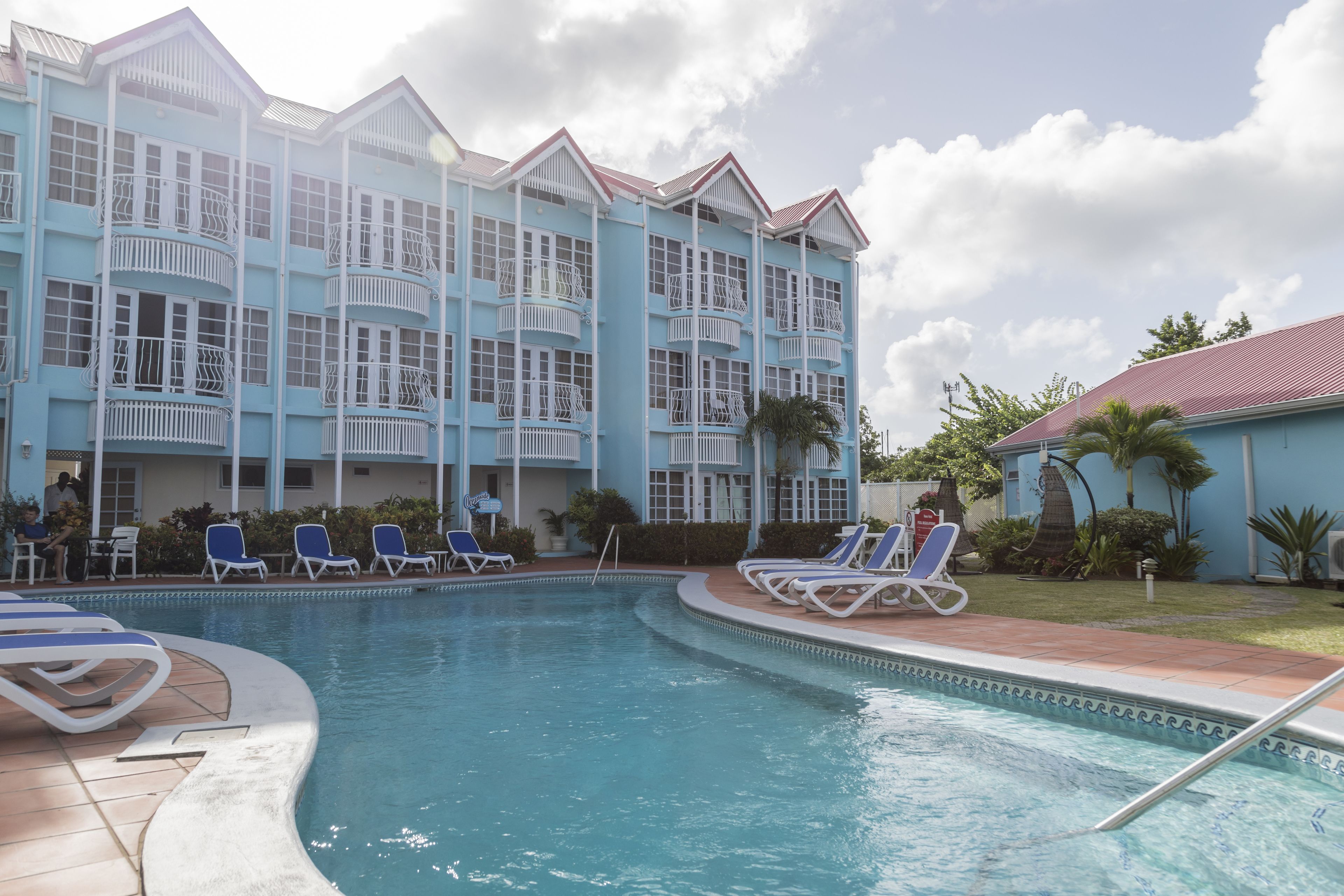 Un hôtel doté d’une piscine, de plusieurs balcons et de chaises longues.