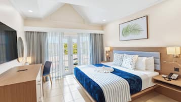 A hotel room with a bed, a desk, a chair, a telephone, and a window with curtains.