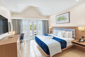 Een hotelkamer met een bed, bureau, stoel, telefoon en raam met gordijnen.