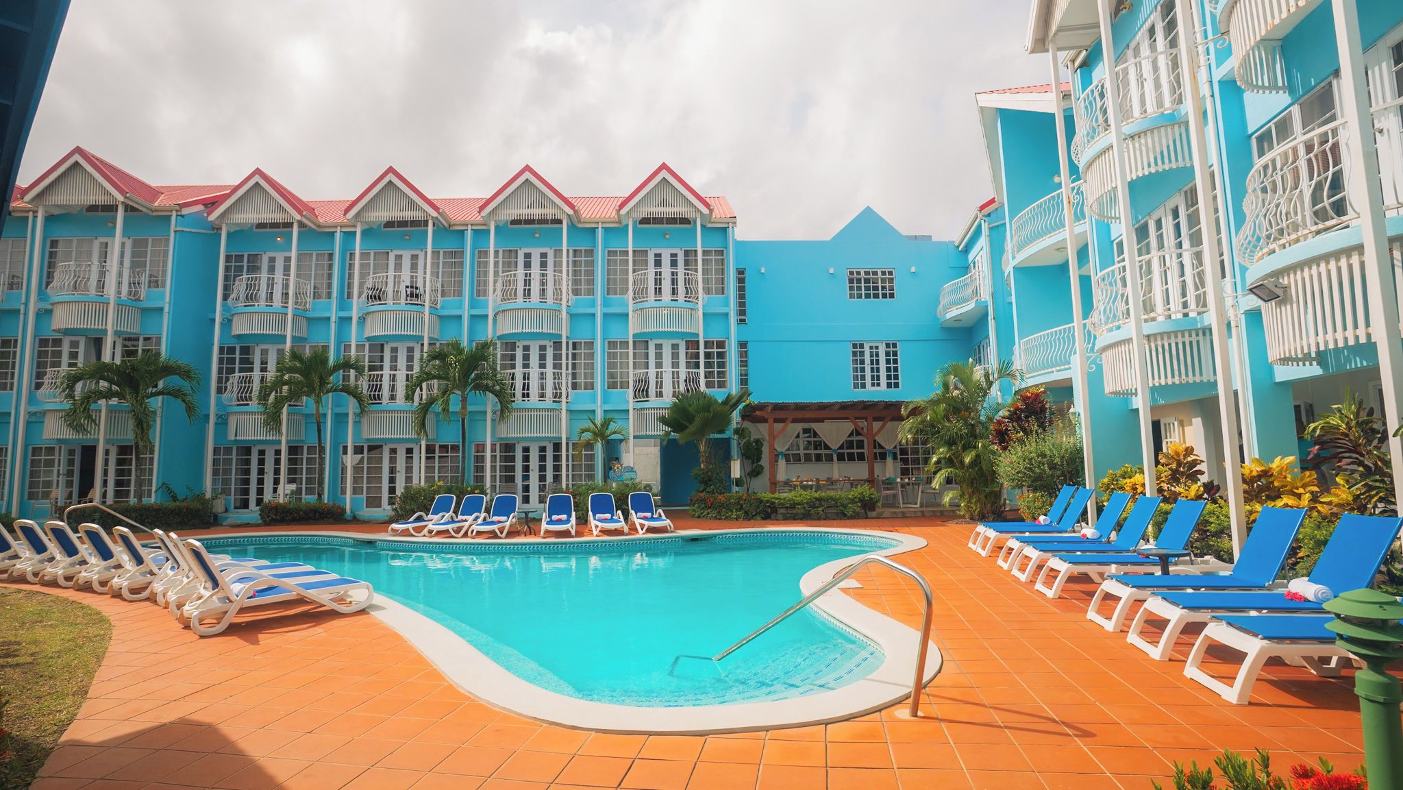 A hotel pool area with multiple lounge chairs and a swimming pool.