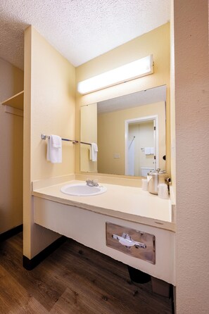 A bathroom with a double sink, a mirror, a towel rack, and a toilet visible in the reflection.