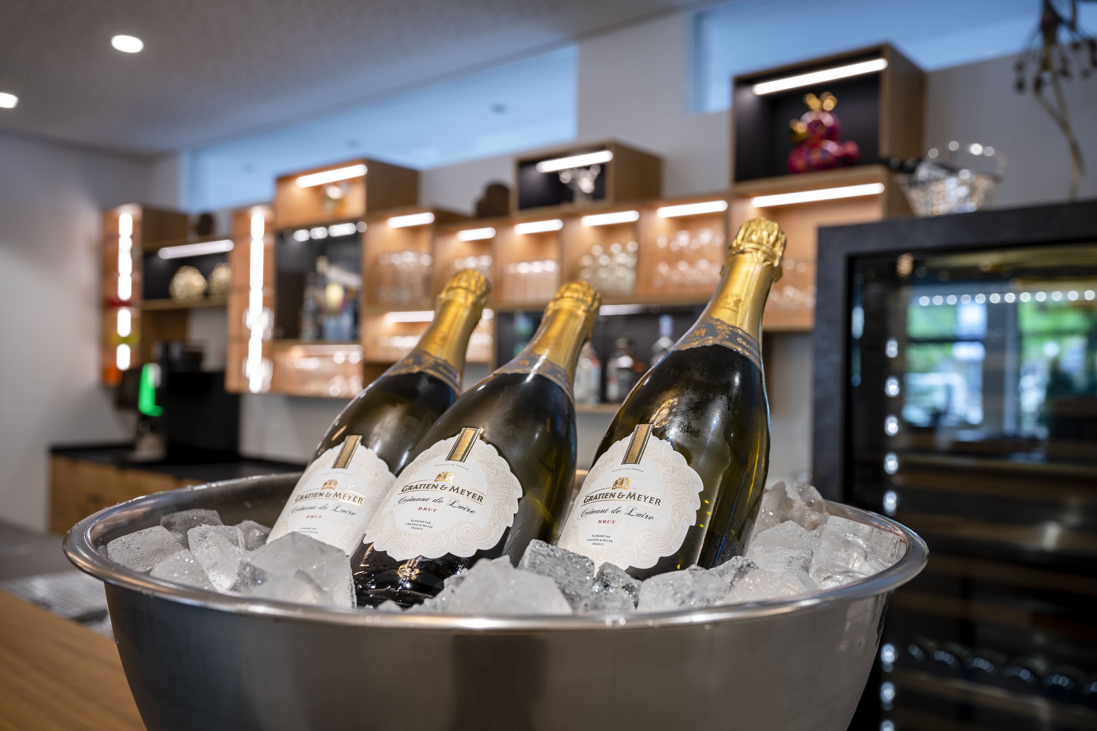 Trois bouteilles de champagne dans un seau en métal rempli de glaçons.