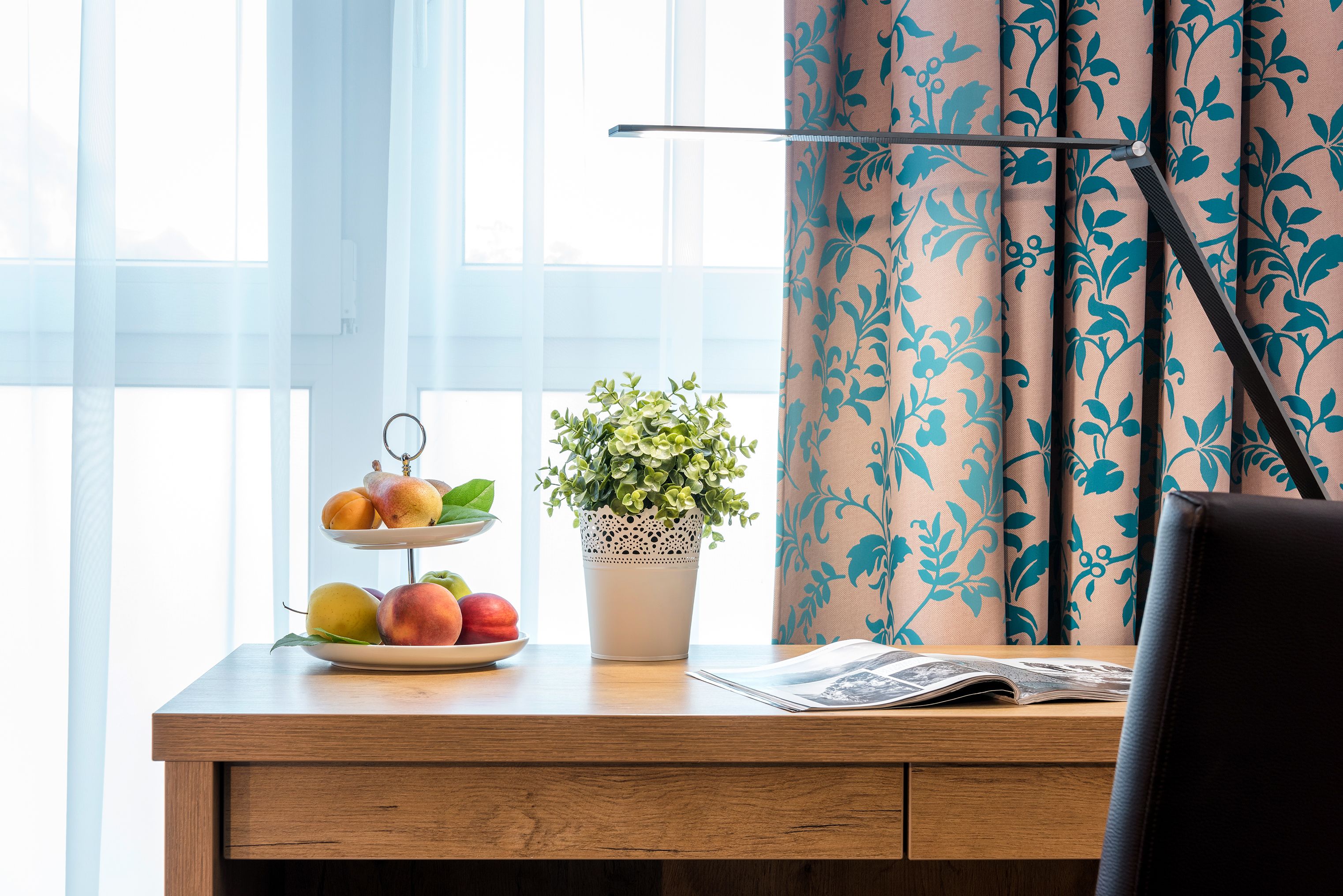Ein Holztisch mit Obstschale, Blumentopf und Zeitung.