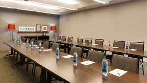 A conference room with a long table, chairs, water bottles, and framed pictures on the wall. - Country Inn & Suites by Radisson, Canton, GA (Canton)