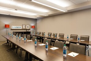 A conference room with a long table, chairs, water bottles, and framed pictures on the wall. - Country Inn & Suites by Radisson, Canton, GA (Canton)