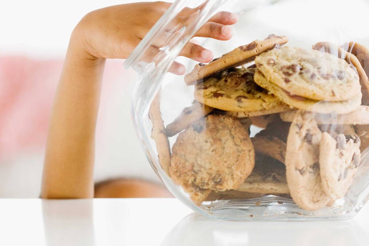 A clear plastic bag filled with cookies and a clear glass container.
