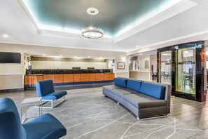 A hotel lobby with a reception desk, seating area, and a modern chandelier. - Comfort Inn & Suites North Charleston - Northwoods (North Charleston)