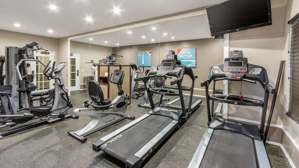 A gym with treadmills, elliptical machines, and weight equipment.