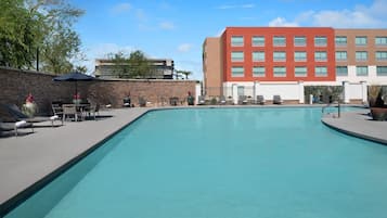 Alberca al aire libre, sombrillas en la alberca y camastros