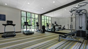 A gym with treadmills, elliptical machines, and weightlifting equipment.