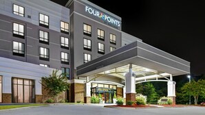 A modern hotel with a covered entrance, multiple windows, and a sign reading "Four Points by Sheraton."
