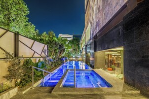 Una piscina al aire libre, sillones reclinables de piscina