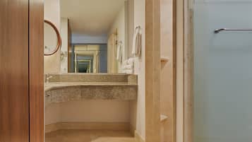A bathroom with a granite countertop, a mirror, and a towel rack.