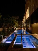 Una piscina al aire libre, sillones reclinables de piscina