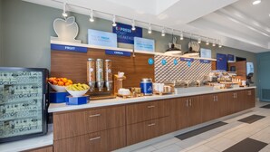 Un espace moderne dédié au petit-déjeuner, avec des zones clairement identifiées pour les fruits, les céréales, les plats chauds et les produits de boulangerie.