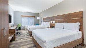 Une chambre d’hôtel avec deux lits, un bureau, une chaise, une télévision et une fenêtre avec des rideaux.