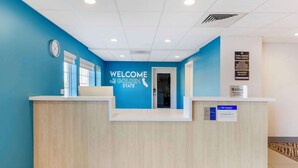 A reception desk with a blue wall, a clock, and a sign welcoming guests to the Golden State. - Executive Residency by Best Western Victorville (Victorville)