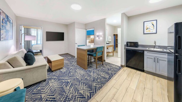A modern apartment with a living room, kitchen, and dining area. - Executive Residency by Best Western Victorville (Victorville)