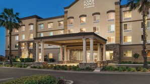 A hotel with a covered entrance, multiple floors, and a stone facade. - Four Points by Sheraton Sacramento International Airport (Sacramento)