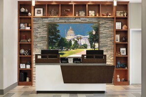A room with a large painting of a capitol building, wooden shelves with various items, and a reception desk. - Four Points by Sheraton Sacramento International Airport (Sacramento)
