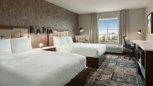 A hotel room with two beds, a desk, a chair, a lamp, and a large window with a view. - Four Points by Sheraton Sacramento International Airport (Sacramento)