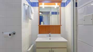 Une salle de bain avec un lavabo blanc, un miroir et un porte-serviettes.