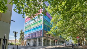 Een modern gebouw met grote ramen en een voetgangersoversteekplaats.