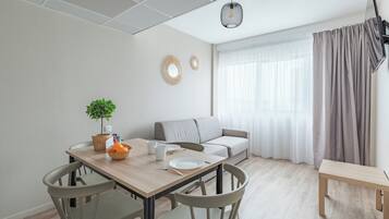 A modern dining area with a wooden table, chairs, and a small potted plant.