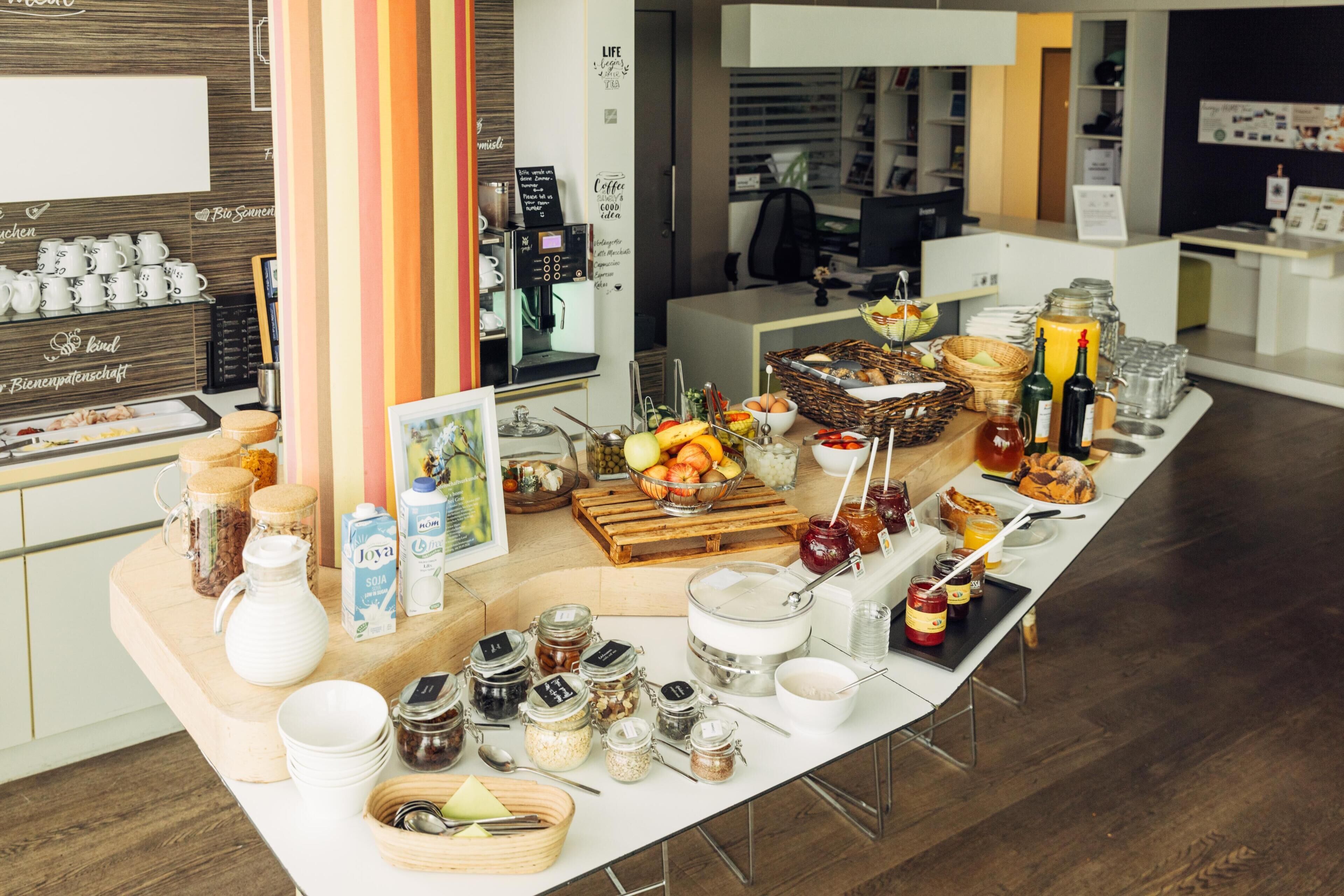 Disposición de un bufé de desayuno con diversos alimentos, bebidas y salsas.