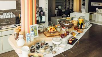 Disposición de un bufé de desayuno con diversos alimentos, bebidas y salsas.
