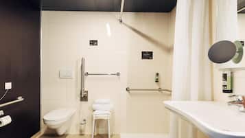 A modern bathroom with a toilet, a sink, and a shower area.