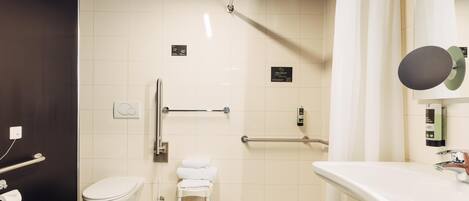 Un baño moderno con inodoro, lavamanos y zona de ducha.